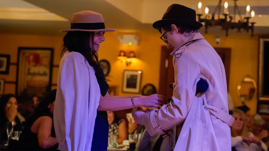 A Murder Mystery Company detective questioning a guest at a New York show
